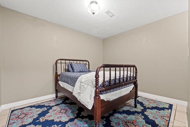 bedroom featuring tile patterned flooring and a textured ceiling