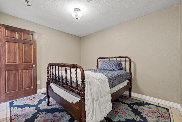 bedroom with tile patterned floors and a textured ceiling