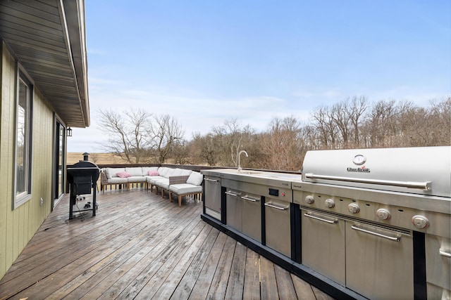 wooden terrace with an outdoor kitchen, sink, outdoor lounge area, and area for grilling