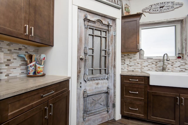 kitchen with decorative backsplash, sink, and dark brown cabinets