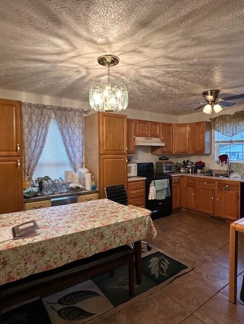 kitchen featuring sink, hanging light fixtures, ceiling fan, black electric range, and a textured ceiling