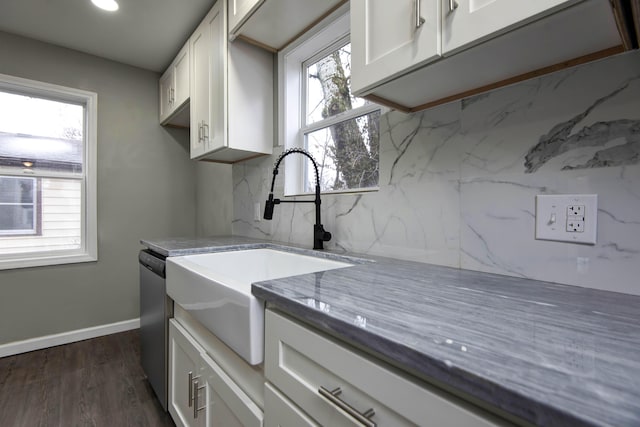 kitchen featuring dark wood-type flooring, sink, white cabinets, stone counters, and backsplash