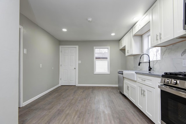 kitchen with stainless steel appliances, tasteful backsplash, sink, and white cabinets