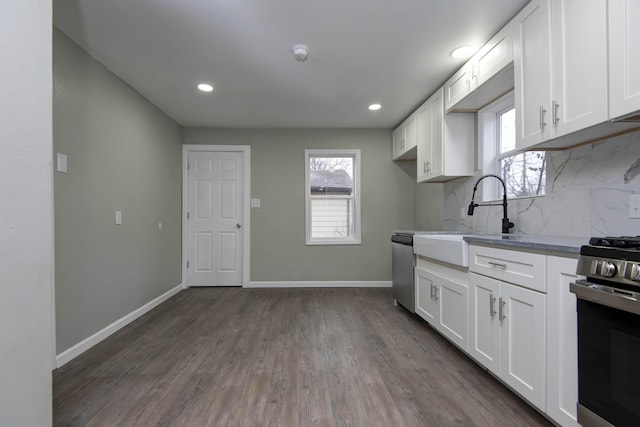 kitchen with white cabinetry, appliances with stainless steel finishes, sink, and decorative backsplash