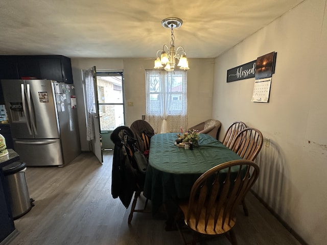 dining area featuring hardwood / wood-style flooring and a notable chandelier