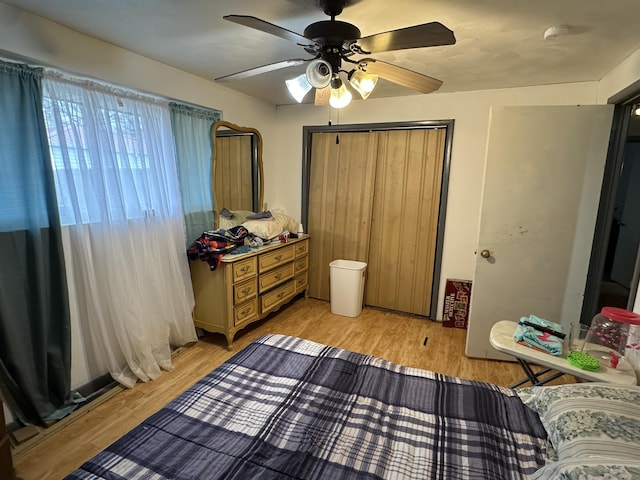 bedroom with ceiling fan, light hardwood / wood-style floors, and a closet