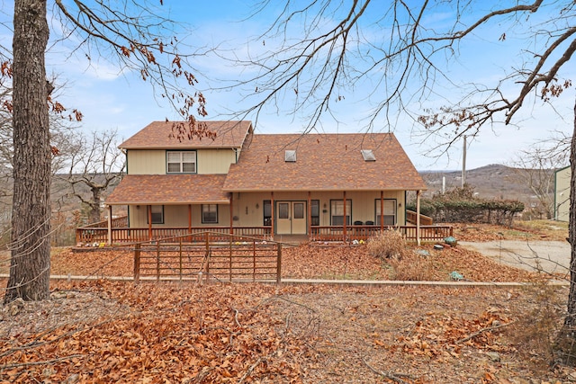 rear view of house featuring a porch and a mountain view