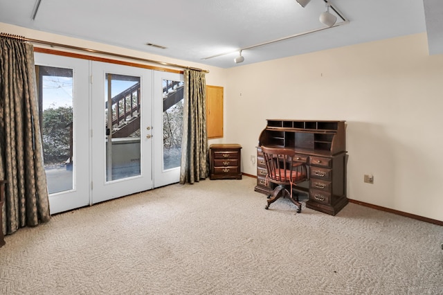 carpeted office space with rail lighting and french doors