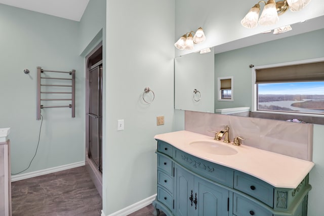 bathroom featuring a shower with door and vanity