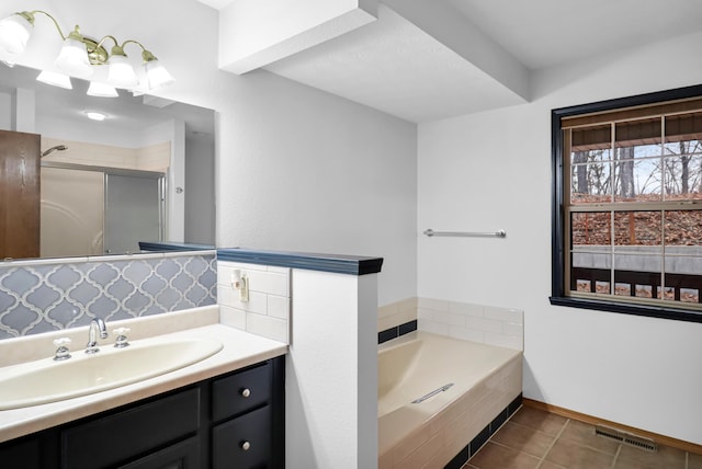 bathroom with tile patterned flooring, vanity, backsplash, and plus walk in shower