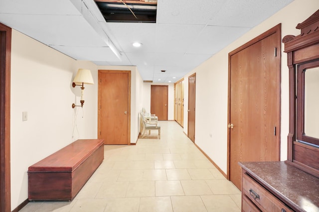 corridor with a paneled ceiling