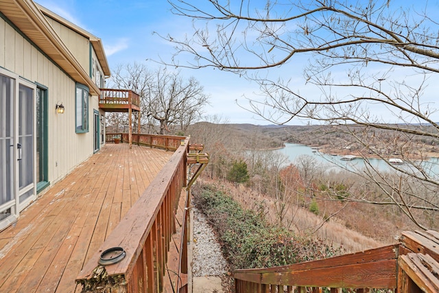 wooden terrace featuring a water and mountain view