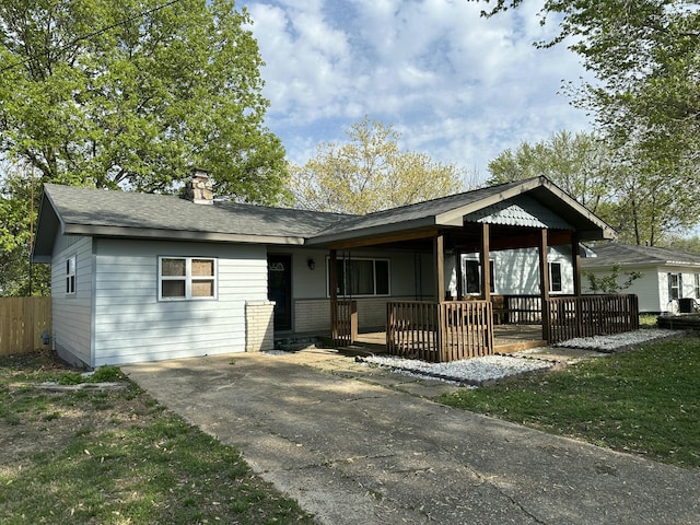 single story home featuring fence, driveway, and a chimney