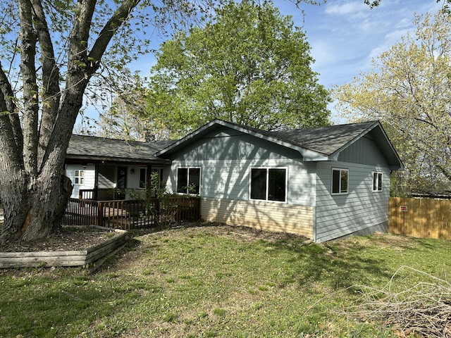 exterior space featuring a yard, roof with shingles, and fence