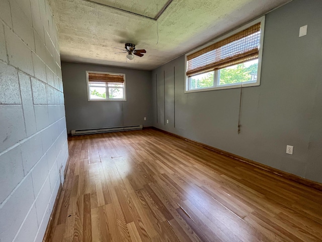 210 Pine St, West Plains, MO 65775 - empty room featuring a baseboard radiator, wood finished floors, a textured ceiling, and a ceiling fan