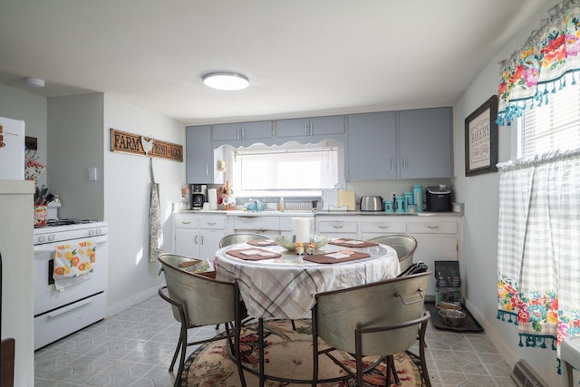 kitchen featuring white gas range and gray cabinetry