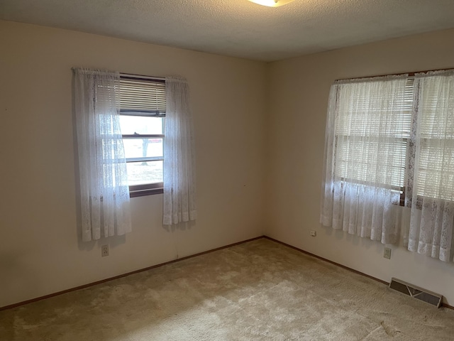 carpeted spare room featuring a textured ceiling