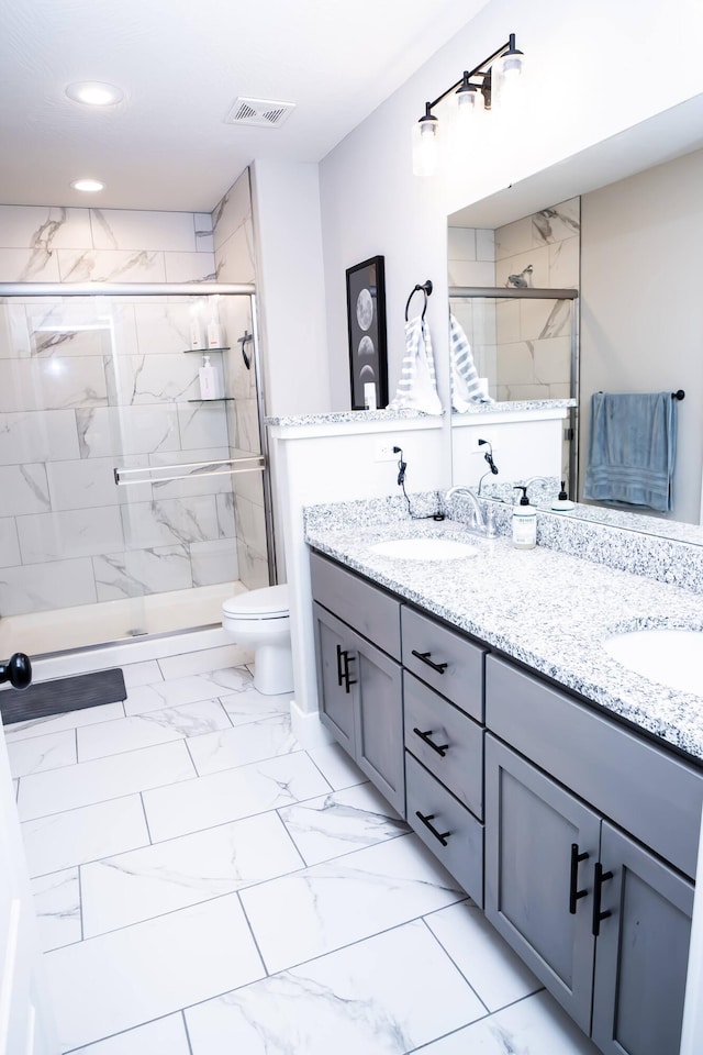 bathroom with vanity, toilet, and a shower with shower door