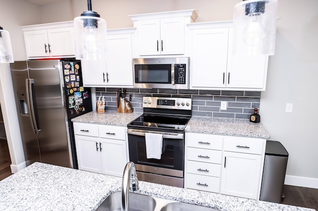 kitchen featuring backsplash, stainless steel appliances, and white cabinets