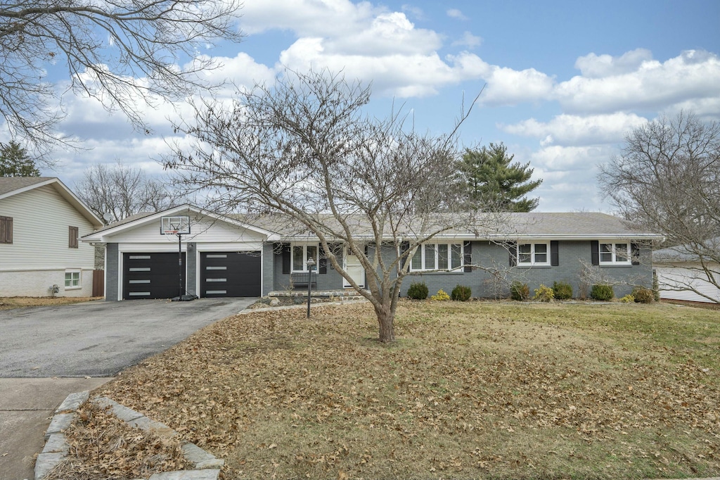 single story home featuring a garage and a front lawn