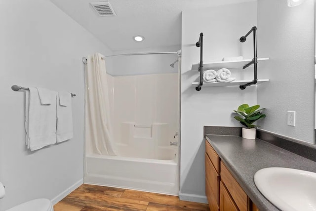 full bathroom featuring vanity, hardwood / wood-style floors, shower / bath combination with curtain, and toilet