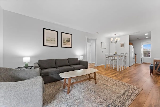 living room with an inviting chandelier and hardwood / wood-style flooring