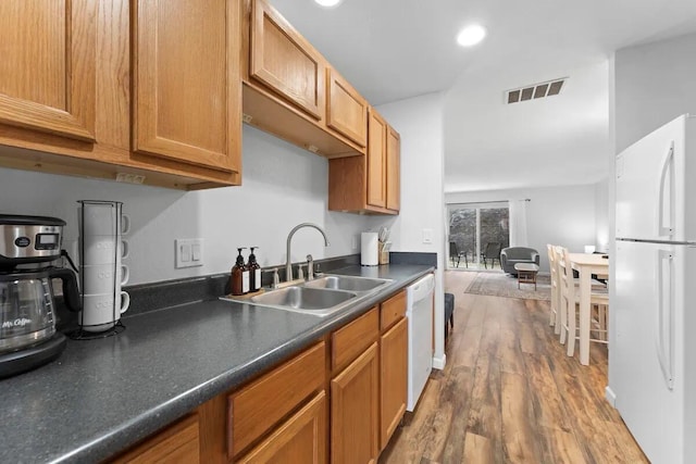 kitchen with sink, white appliances, and hardwood / wood-style floors