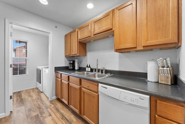 kitchen with dishwasher, sink, washer and dryer, and light hardwood / wood-style flooring