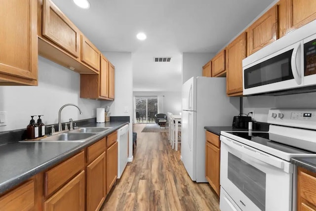 kitchen with sink, white appliances, and light wood-type flooring