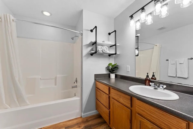 bathroom with hardwood / wood-style flooring, shower / tub combo with curtain, and vanity