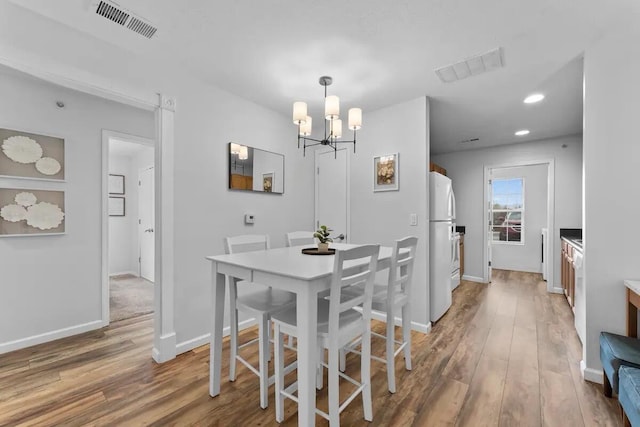 dining room featuring hardwood / wood-style floors and a notable chandelier