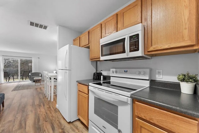 kitchen with white appliances and light hardwood / wood-style floors