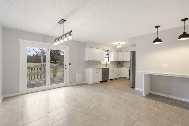 kitchen with appliances with stainless steel finishes, pendant lighting, white cabinetry, sink, and a textured ceiling