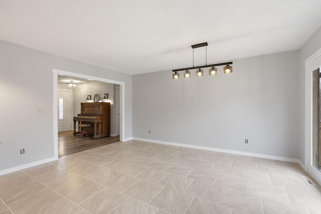 tiled spare room with a textured ceiling