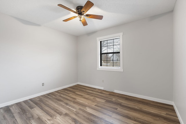 spare room featuring ceiling fan, dark hardwood / wood-style floors, and a textured ceiling