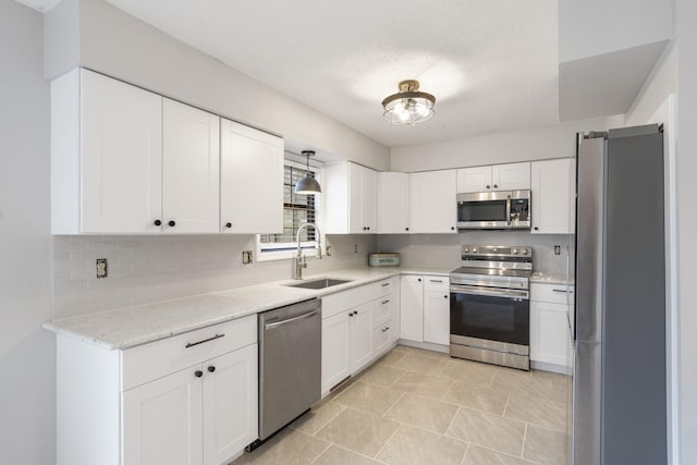 kitchen with white cabinetry, sink, tasteful backsplash, and stainless steel appliances