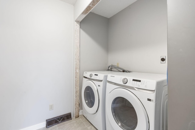 washroom featuring separate washer and dryer and light tile patterned floors