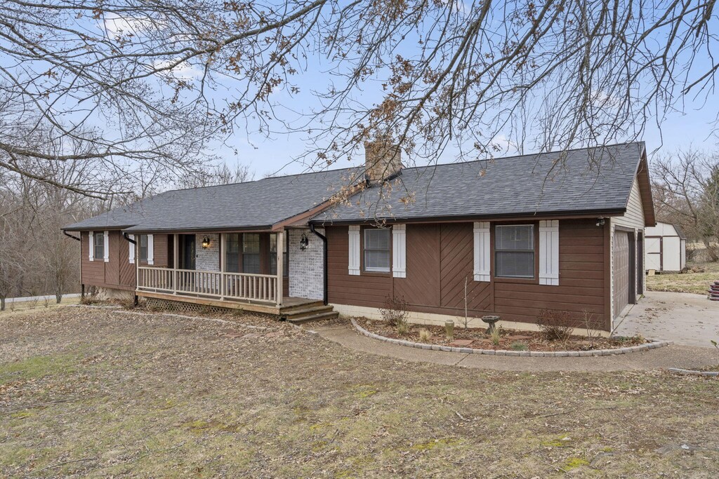 1552 W Oak Ridge Ct, Nixa, MO 65714 - ranch-style home with a porch and a garage