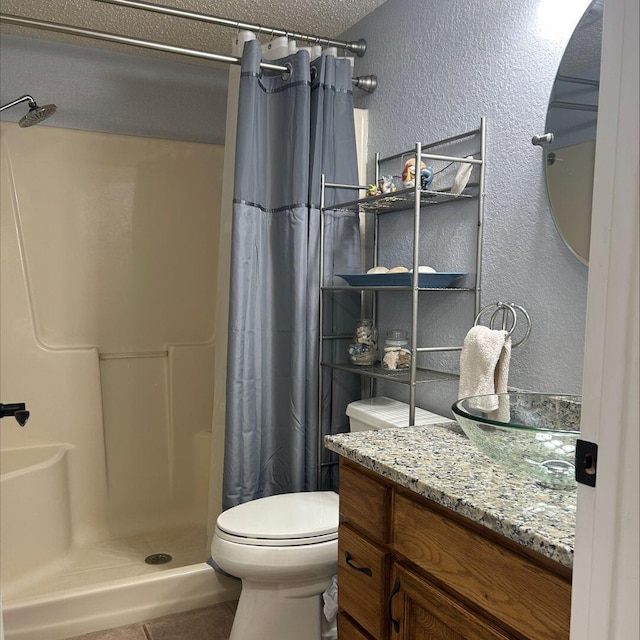 bathroom featuring tile patterned floors, toilet, a textured ceiling, vanity, and curtained shower