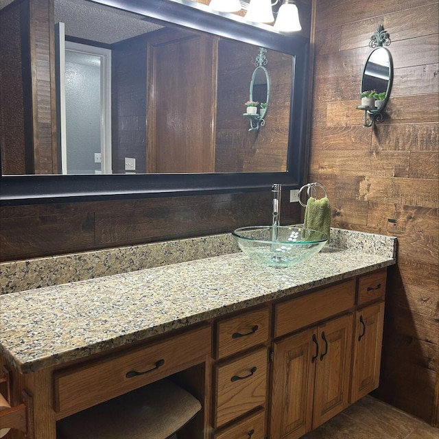 bathroom with vanity and wood walls