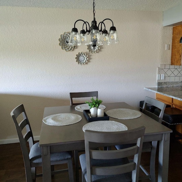 dining space with dark hardwood / wood-style floors and an inviting chandelier