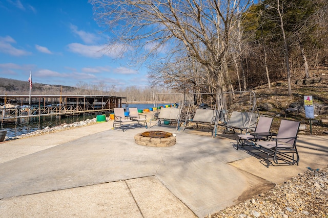 view of patio featuring an outdoor fire pit and a water view