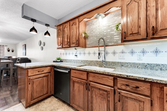 kitchen with light stone countertops, sink, stainless steel dishwasher, a textured ceiling, and pendant lighting