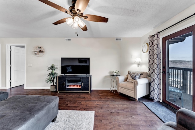 living room with a textured ceiling, hardwood / wood-style flooring, and ceiling fan