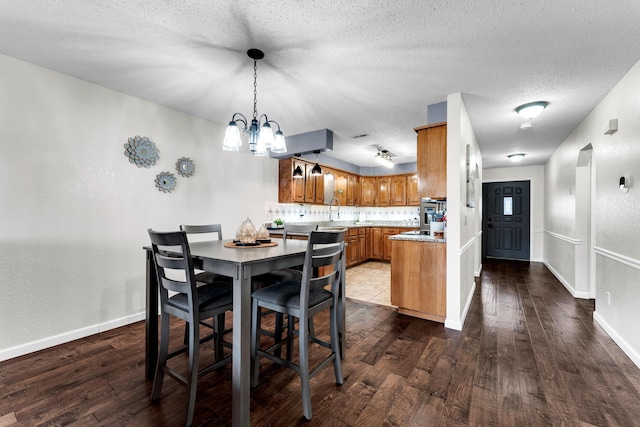 dining room with dark hardwood / wood-style flooring, a chandelier, and a textured ceiling