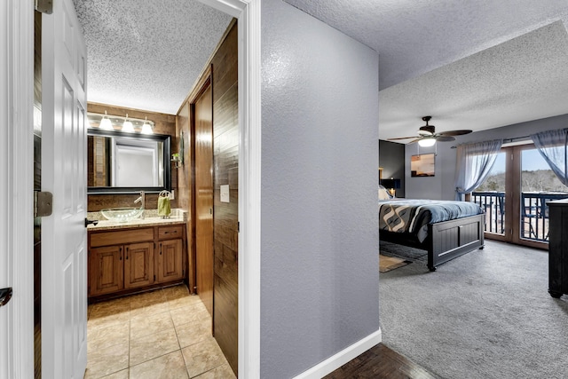 bathroom with tile patterned floors, a textured ceiling, ceiling fan, and vanity