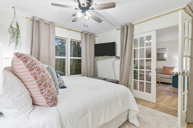 bedroom with hardwood / wood-style flooring, ceiling fan, and french doors