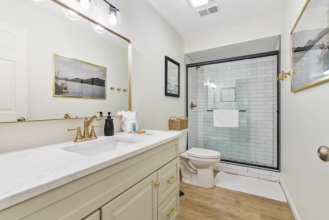 bathroom with walk in shower, vanity, toilet, and wood-type flooring