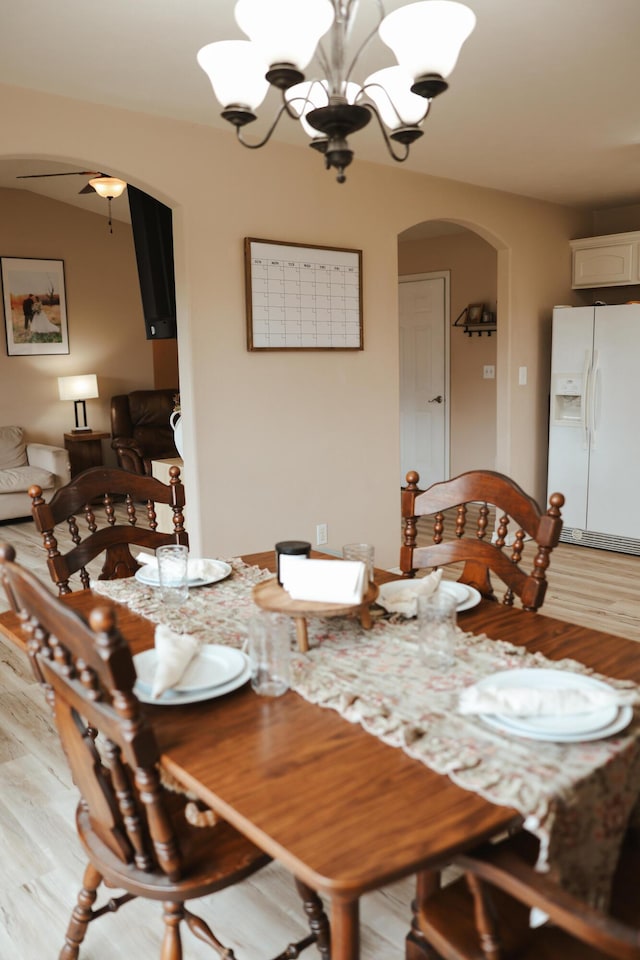 1610 Jon St, West Plains, MO 65775 - dining room featuring arched walkways, a chandelier, light wood finished floors, and a ceiling fan