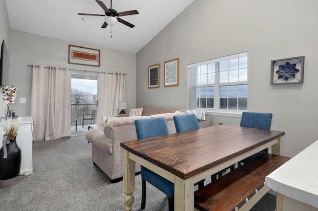 carpeted dining area featuring ceiling fan and high vaulted ceiling